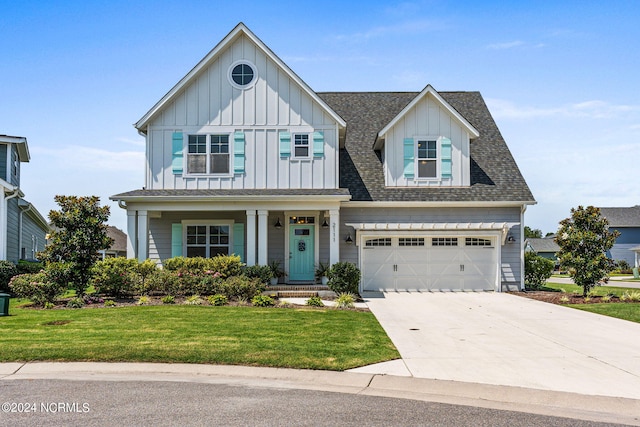 view of front of house with a front yard, a garage, and a porch