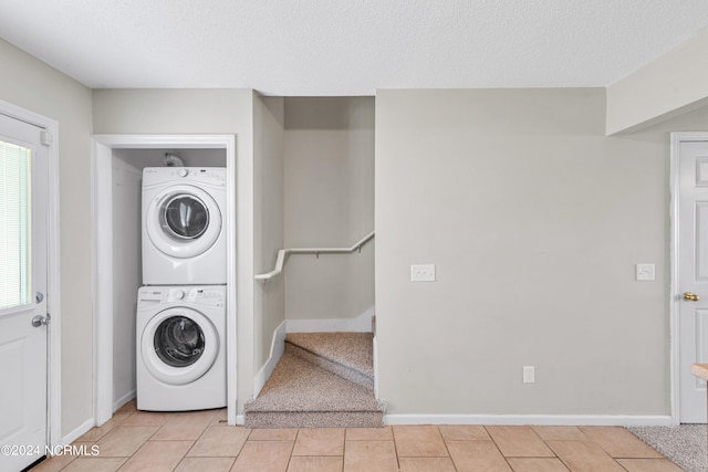 washroom with a textured ceiling, light colored carpet, and stacked washing maching and dryer