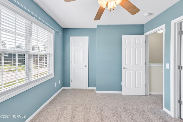 unfurnished bedroom featuring ceiling fan and carpet flooring