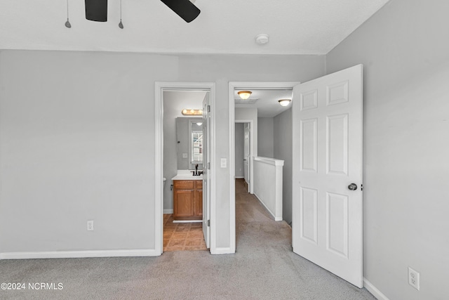 unfurnished bedroom with a sink, carpet floors, connected bathroom, and baseboards