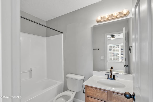 full bathroom featuring toilet, tub / shower combination, vanity, ceiling fan, and a textured ceiling