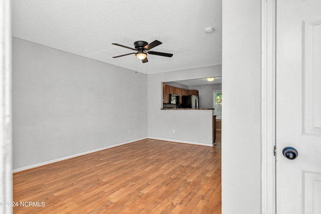 unfurnished living room with hardwood / wood-style floors, ceiling fan, and a textured ceiling