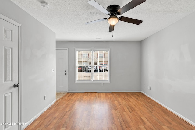 spare room featuring ceiling fan, a textured ceiling, baseboards, and wood finished floors
