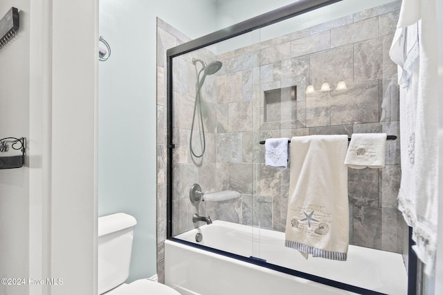 bathroom featuring toilet and enclosed tub / shower combo