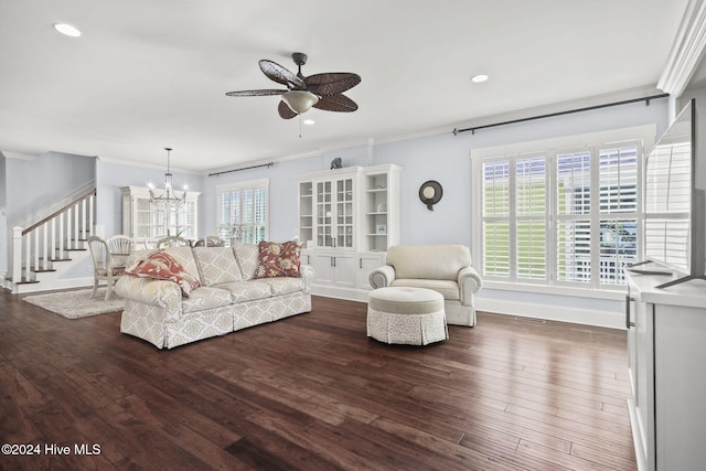 living room featuring ornamental molding, dark hardwood / wood-style flooring, and ceiling fan with notable chandelier