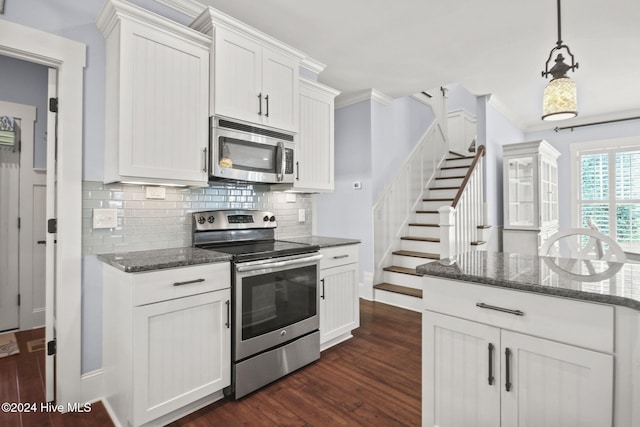 kitchen with stainless steel appliances, backsplash, ornamental molding, white cabinetry, and dark hardwood / wood-style flooring