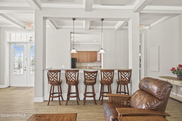 kitchen featuring a peninsula, pendant lighting, a breakfast bar, beamed ceiling, and decorative backsplash