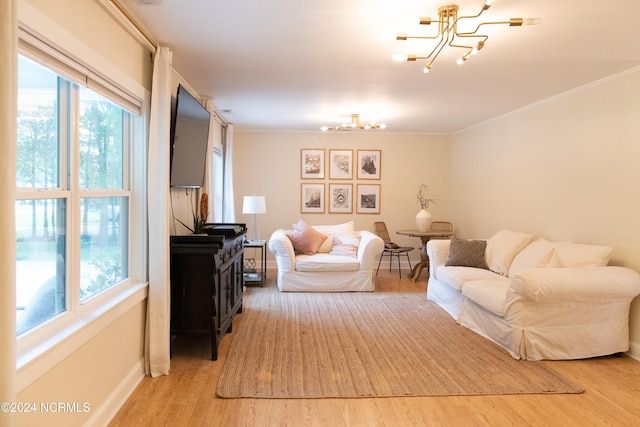 living room with crown molding, hardwood / wood-style floors, and an inviting chandelier