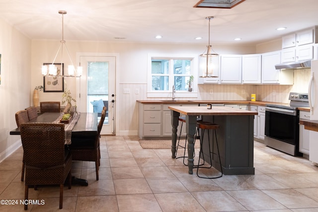 kitchen with white cabinets, electric range, decorative light fixtures, and a chandelier