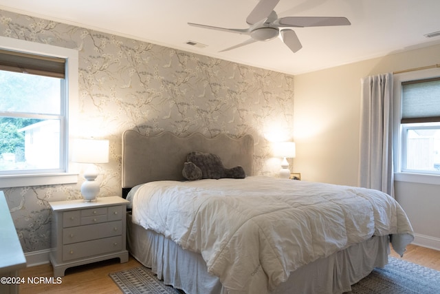 bedroom with ceiling fan, ornamental molding, and light hardwood / wood-style flooring