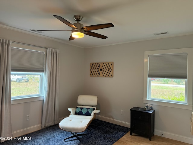 sitting room featuring ceiling fan, plenty of natural light, ornamental molding, and light wood-type flooring