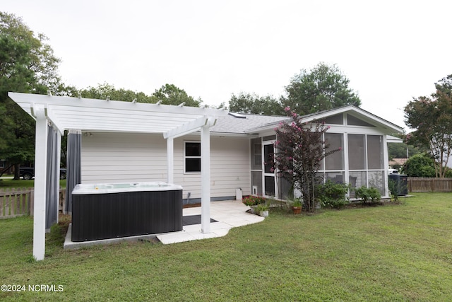 back of property featuring a hot tub, a lawn, a sunroom, fence, and a pergola