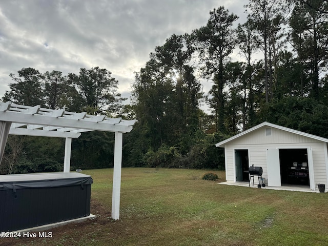 view of yard featuring an outbuilding, a pergola, and a hot tub