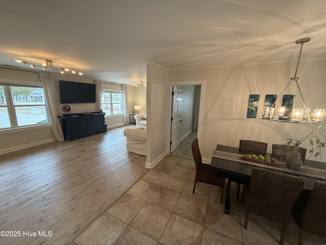 dining room featuring baseboards, a chandelier, and wood finished floors