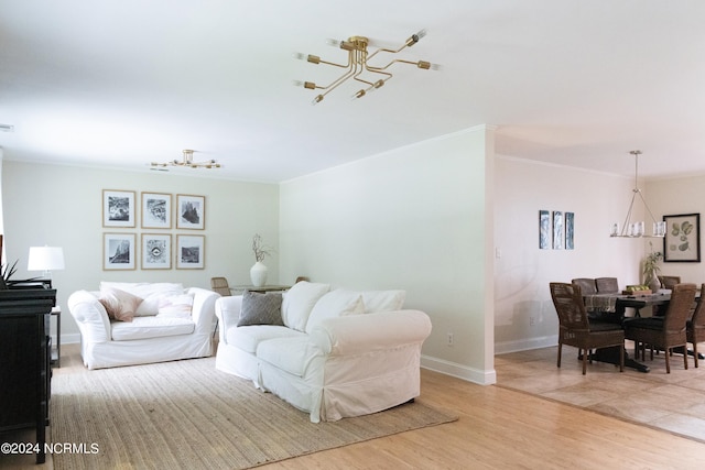 living room with a chandelier, light hardwood / wood-style flooring, and ornamental molding