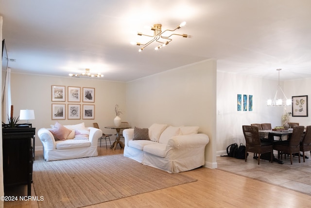 living room with crown molding, light hardwood / wood-style floors, and a notable chandelier