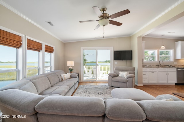 living room with light wood-type flooring, crown molding, lofted ceiling, and ceiling fan