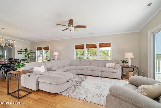 living room with crown molding, light hardwood / wood-style flooring, and ceiling fan with notable chandelier