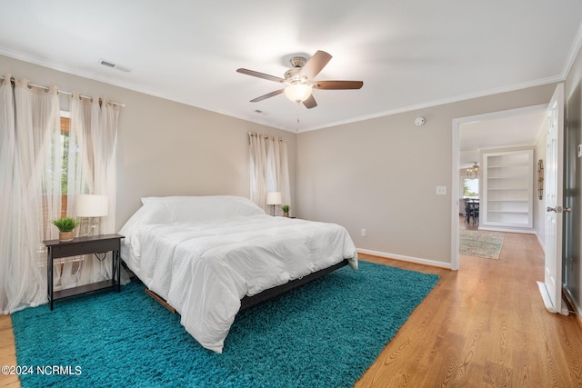 bedroom featuring hardwood / wood-style flooring, ceiling fan, and ornamental molding