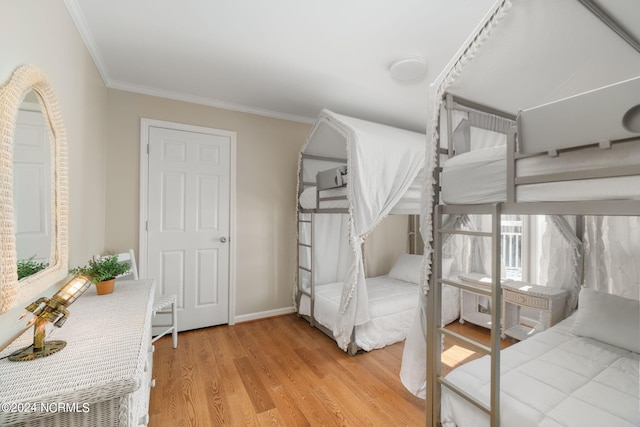 bedroom with crown molding and light hardwood / wood-style floors