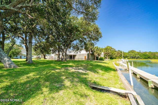 dock area featuring a lawn and a water view