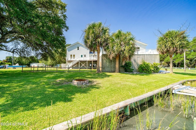 view of yard with a deck with water view and an outdoor fire pit