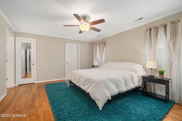 bedroom with ceiling fan, ornamental molding, and hardwood / wood-style floors