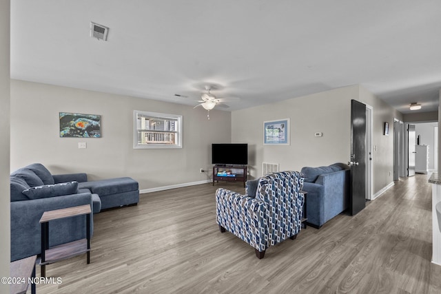 living room featuring ceiling fan and hardwood / wood-style flooring