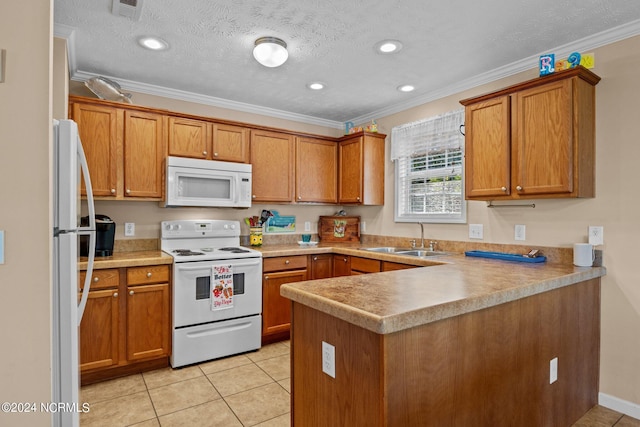 kitchen featuring a peninsula, white appliances, a sink, and brown cabinets