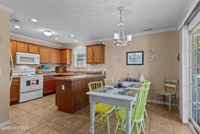 kitchen with a peninsula, white appliances, brown cabinetry, and crown molding