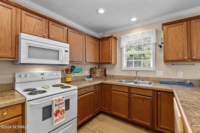 kitchen featuring crown molding, white appliances, brown cabinets, and a sink