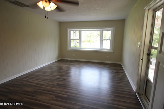 unfurnished room with a textured ceiling, ceiling fan, and dark hardwood / wood-style floors