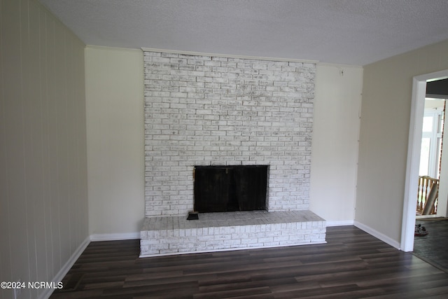 details with a textured ceiling, hardwood / wood-style flooring, and a brick fireplace