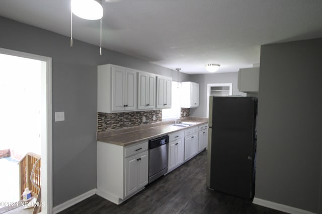 kitchen with decorative backsplash, black refrigerator, white cabinets, and stainless steel dishwasher