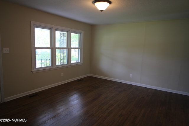 empty room with dark hardwood / wood-style flooring