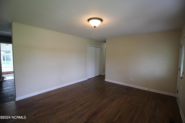 unfurnished room featuring dark wood-type flooring