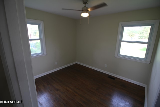 empty room with ceiling fan and dark hardwood / wood-style floors