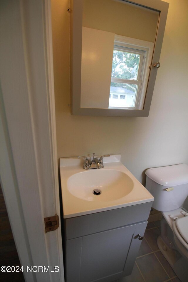 bathroom featuring tile patterned floors, vanity, and toilet