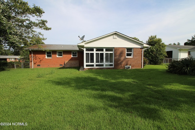 back of house with a yard and a sunroom