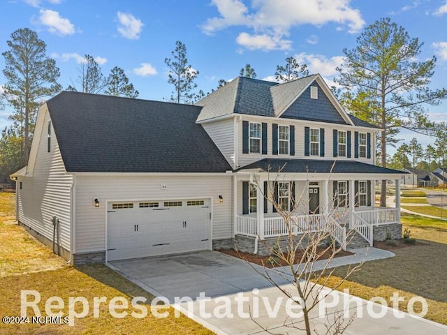 view of front of property with an attached garage, covered porch, concrete driveway, and roof with shingles