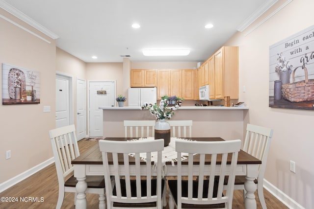 dining space with light wood finished floors, baseboards, ornamental molding, and recessed lighting