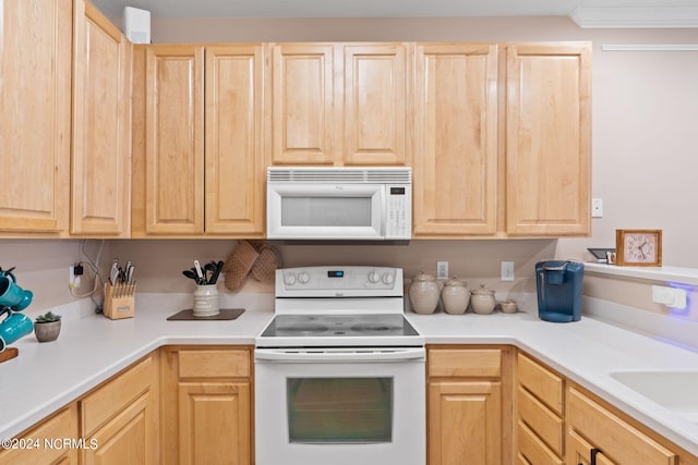 kitchen featuring light countertops, white appliances, and light brown cabinets