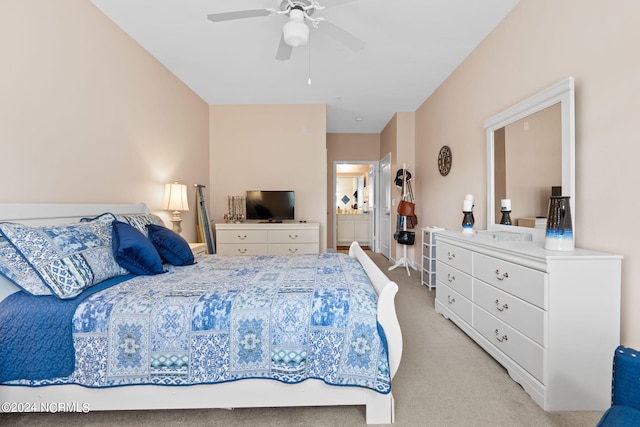 bedroom with light carpet, ensuite bath, and a ceiling fan