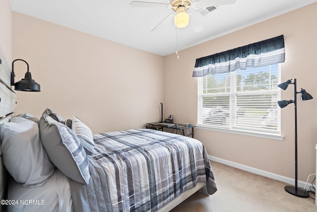 carpeted bedroom with visible vents, a ceiling fan, and baseboards