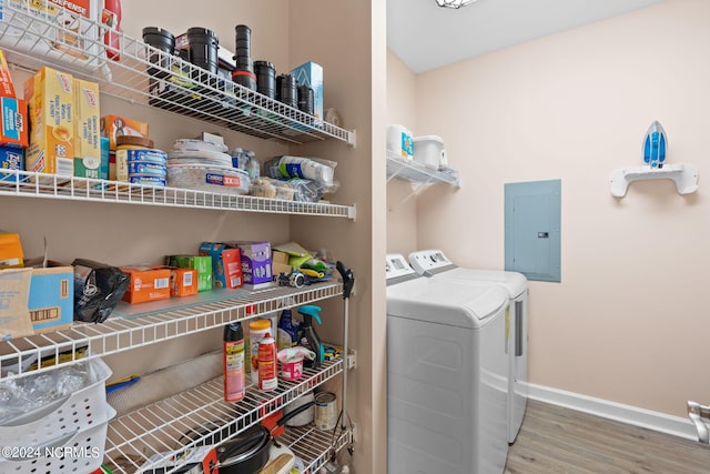 clothes washing area featuring laundry area, separate washer and dryer, wood finished floors, baseboards, and electric panel