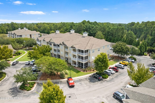 birds eye view of property featuring a view of trees