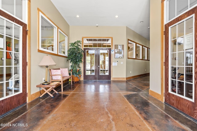 foyer with recessed lighting, french doors, concrete floors, and baseboards