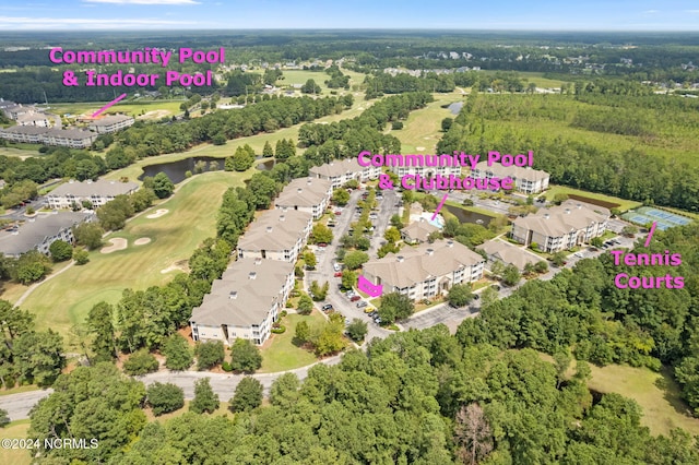 drone / aerial view featuring view of golf course, a forest view, and a residential view