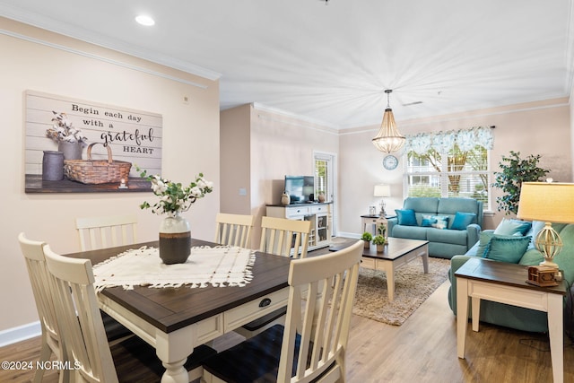 dining room with baseboards, wood finished floors, crown molding, a chandelier, and recessed lighting