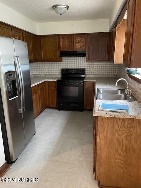 kitchen with black electric range, tasteful backsplash, sink, stainless steel fridge with ice dispenser, and light tile patterned floors